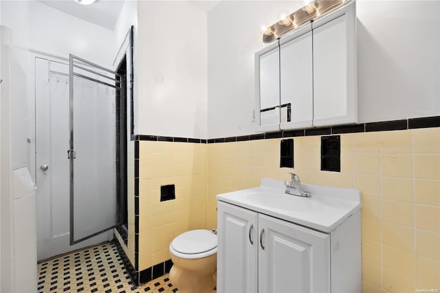 bathroom with vanity, curtained shower, toilet, and tile walls