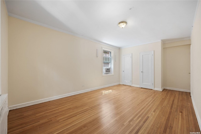 unfurnished bedroom featuring hardwood / wood-style floors, cooling unit, and crown molding