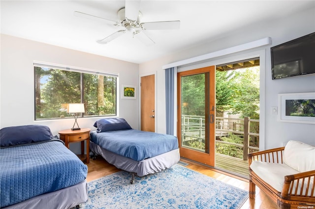 bedroom with multiple windows, ceiling fan, light hardwood / wood-style flooring, and access to exterior