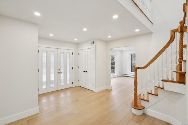 entrance foyer with a baseboard radiator and light wood-type flooring