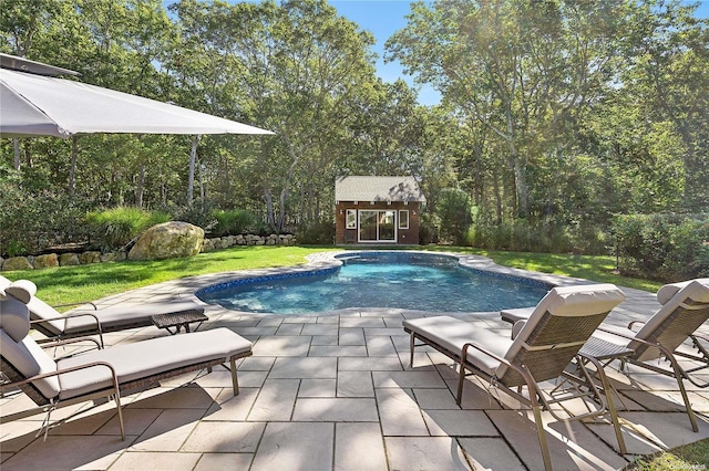 view of swimming pool featuring a yard, a patio, and an outdoor structure