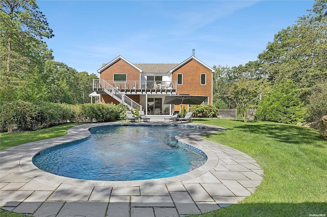 view of swimming pool featuring a lawn, a patio area, and a deck