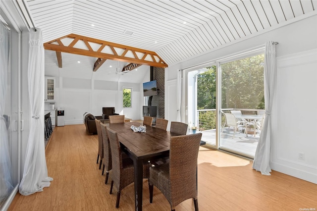 dining space with lofted ceiling with beams, light hardwood / wood-style floors, and wood ceiling