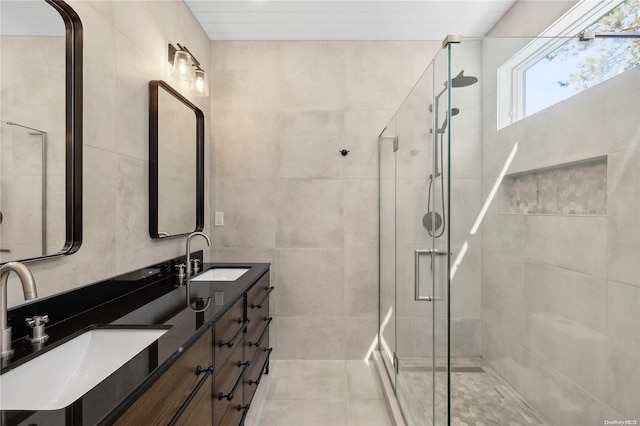 bathroom with a shower with door, vanity, and tile patterned flooring