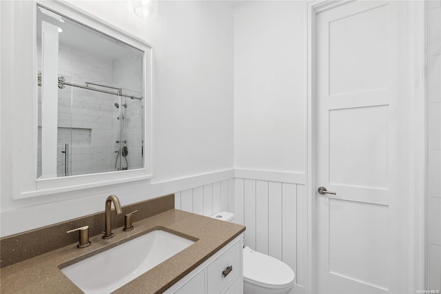 bathroom featuring vanity, toilet, and a shower with door