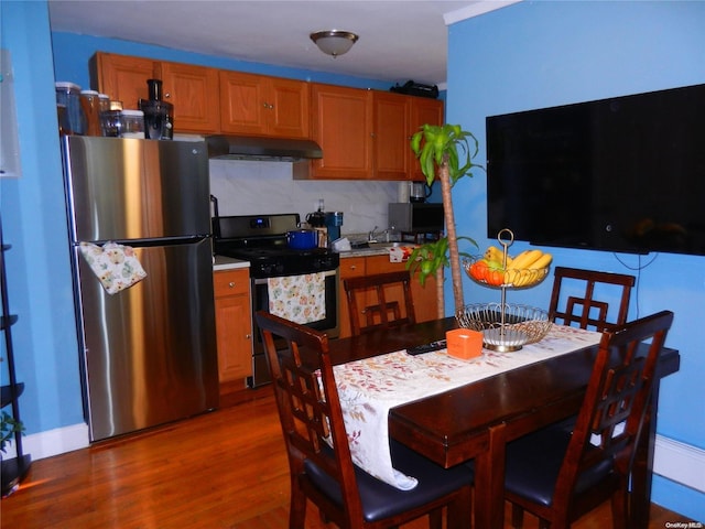 kitchen featuring dark hardwood / wood-style flooring, decorative backsplash, and stainless steel appliances