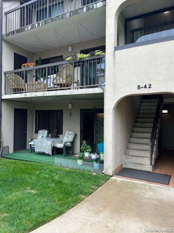 entrance to property with a yard and a balcony