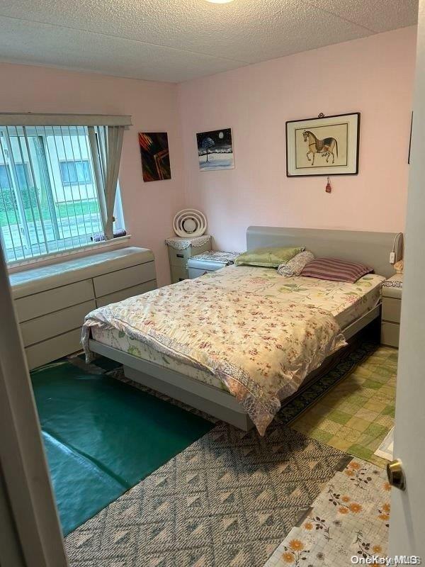 bedroom with carpet flooring and a textured ceiling