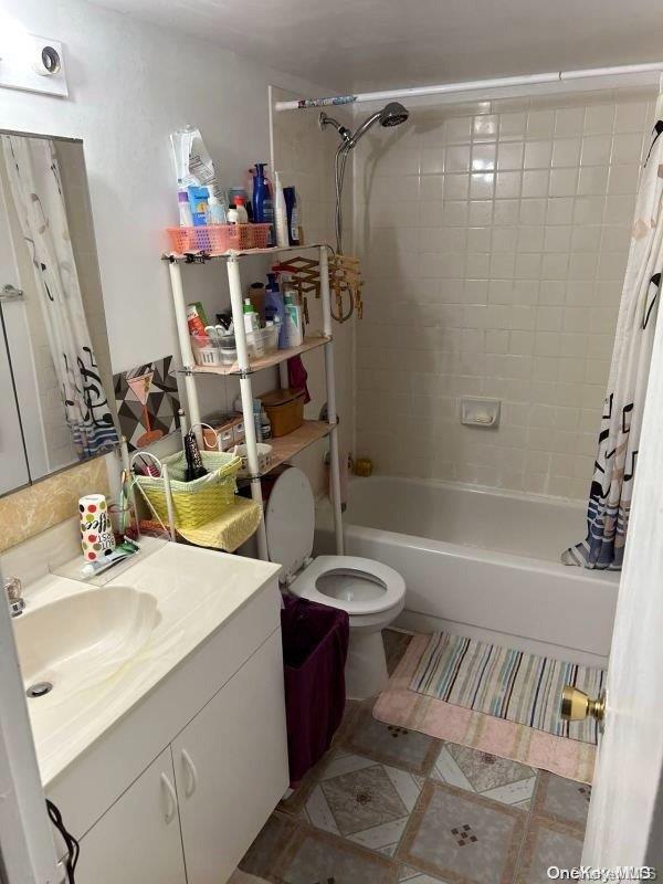 full bathroom with vanity, shower / bath combo, and toilet