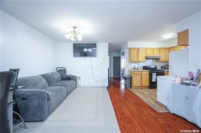 living room featuring a notable chandelier and light hardwood / wood-style floors