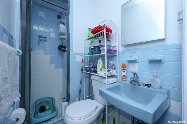 bathroom with sink, walk in shower, backsplash, toilet, and tile walls