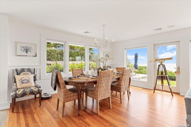 dining area featuring an inviting chandelier and light hardwood / wood-style flooring