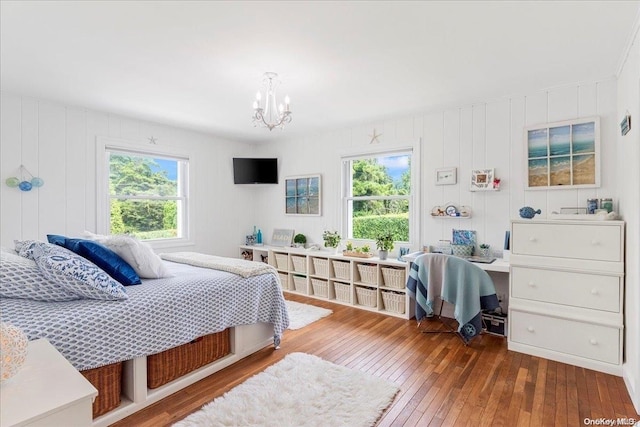 bedroom featuring multiple windows, hardwood / wood-style floors, and a notable chandelier