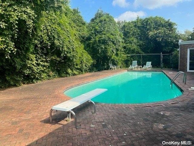 view of pool featuring a patio area and a diving board