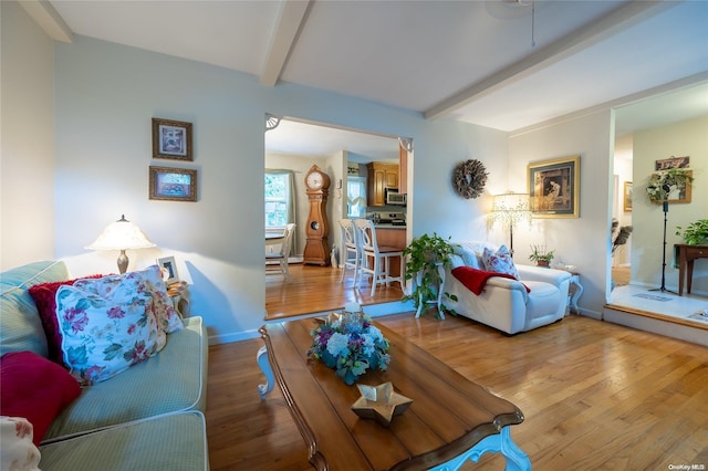 living room featuring beamed ceiling and hardwood / wood-style flooring