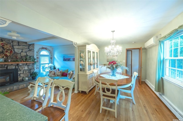 dining area with a wood stove, light hardwood / wood-style floors, an AC wall unit, and baseboard heating