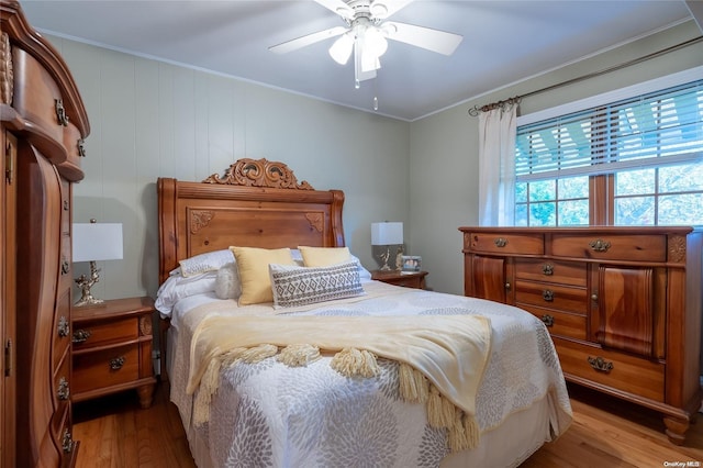 bedroom with light hardwood / wood-style flooring, ceiling fan, and crown molding