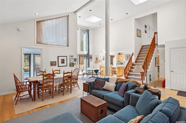 living room with beamed ceiling, light hardwood / wood-style floors, and high vaulted ceiling