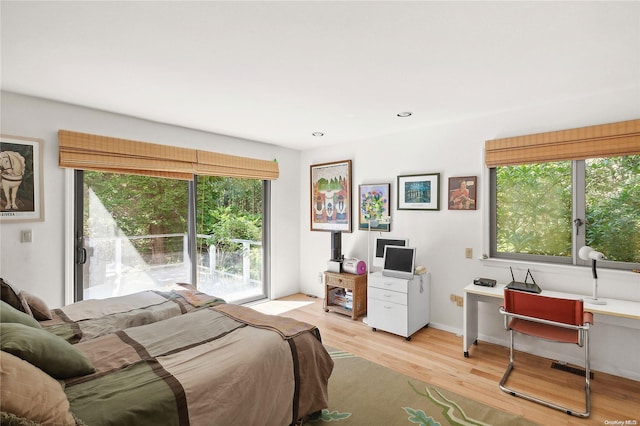 bedroom with light hardwood / wood-style floors, access to exterior, and multiple windows