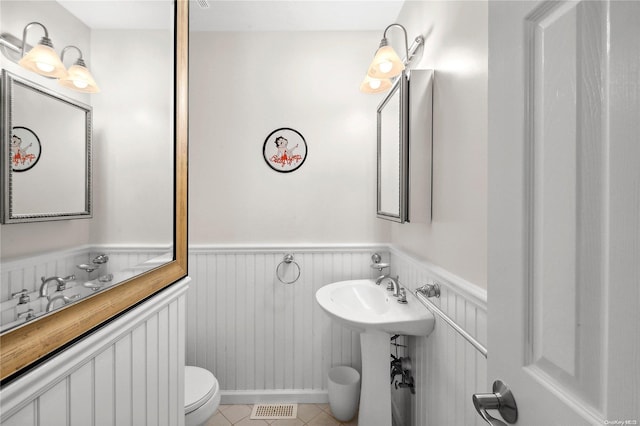 bathroom featuring toilet, tile patterned floors, and sink