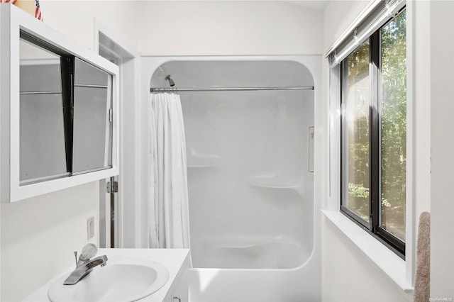 bathroom featuring vanity, a healthy amount of sunlight, and shower / bath combo