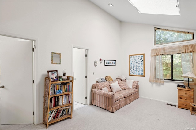 sitting room with light colored carpet and high vaulted ceiling