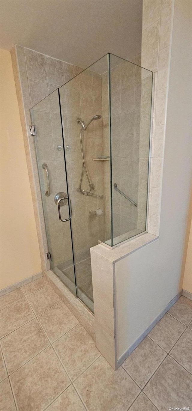 bathroom with tile patterned flooring and a shower with door