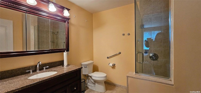 bathroom featuring vanity, toilet, and a shower with shower door