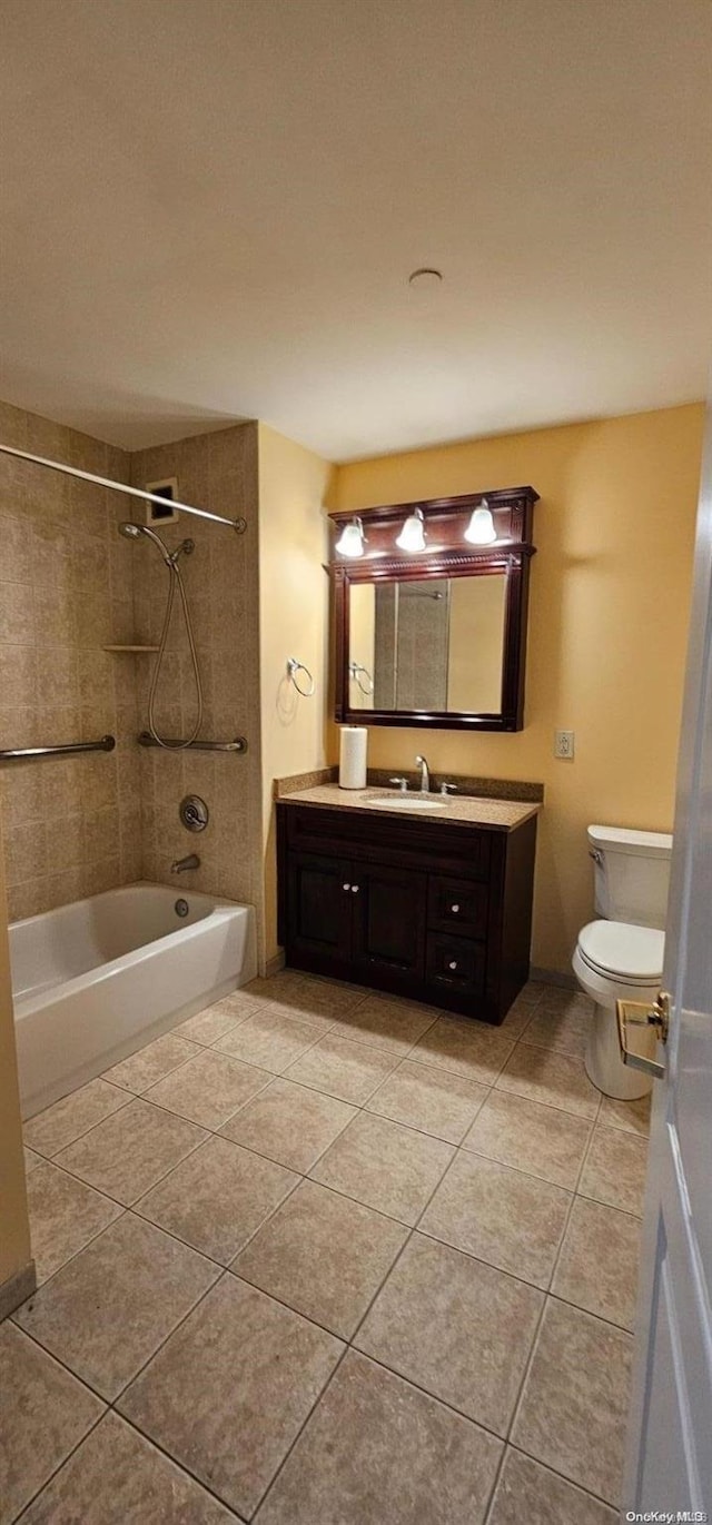 full bathroom with tile patterned floors, vanity, toilet, and tiled shower / bath combo