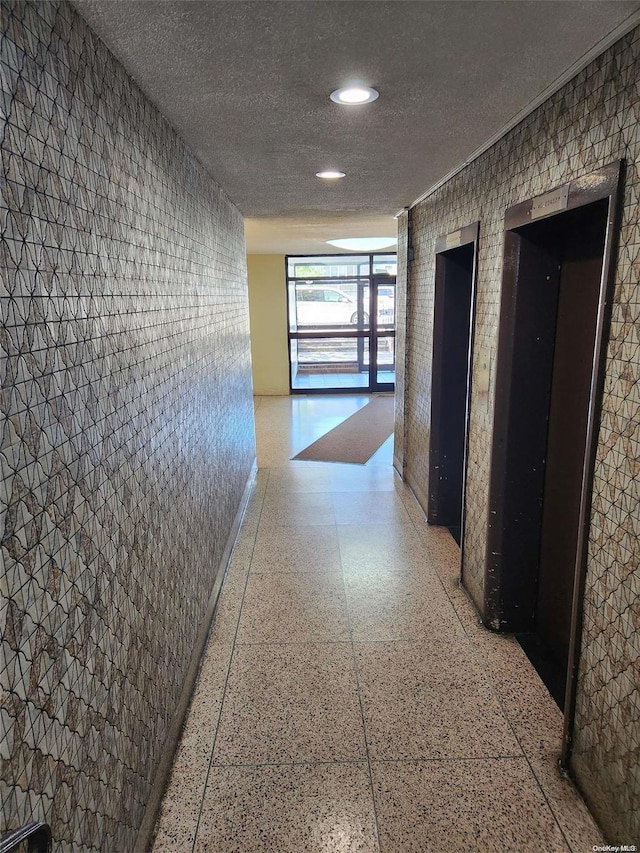 hall with a textured ceiling