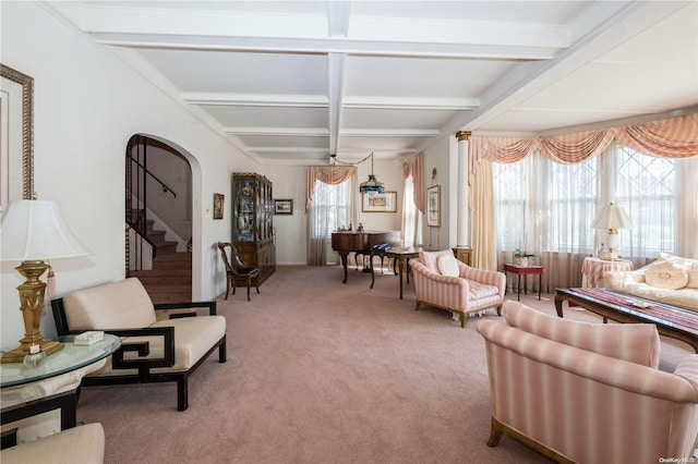 carpeted living room with beamed ceiling