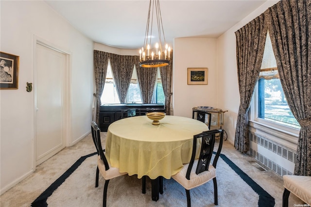 dining area with radiator, light colored carpet, and an inviting chandelier