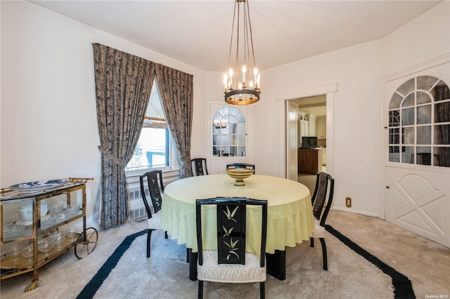 carpeted dining area featuring an inviting chandelier