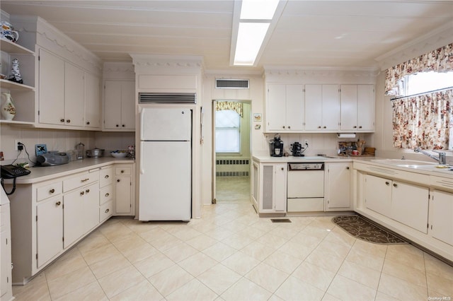 kitchen featuring white appliances, white cabinets, crown molding, light tile patterned floors, and radiator heating unit