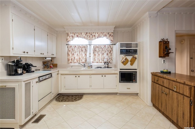 kitchen with white cabinetry, crown molding, light tile patterned floors, and white appliances