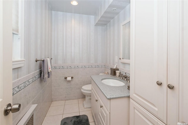 bathroom with tile patterned floors, vanity, tile walls, and toilet