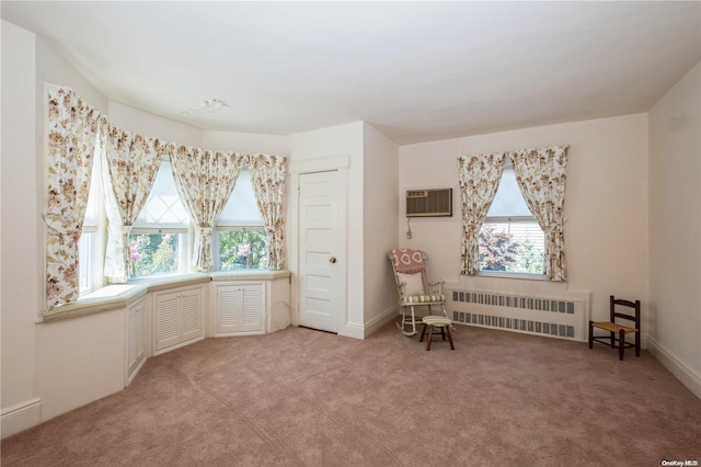 living area featuring light colored carpet, a wall unit AC, and radiator