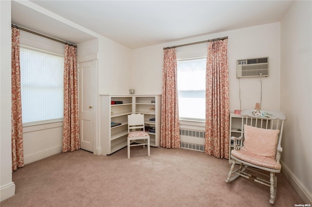 living area featuring carpet flooring, radiator heating unit, and an AC wall unit