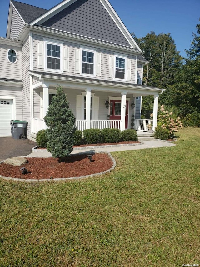 view of front of property with a front yard, a garage, and covered porch