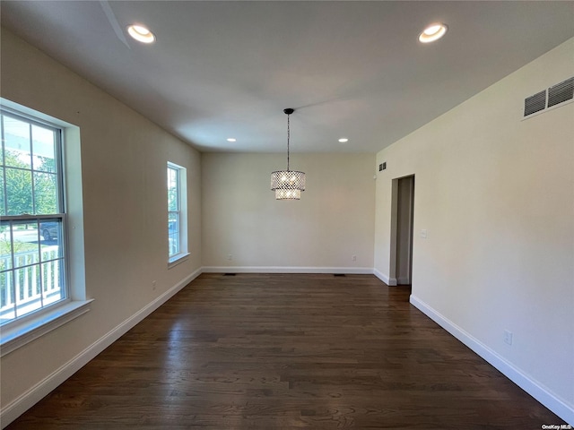 unfurnished dining area with dark hardwood / wood-style flooring and an inviting chandelier