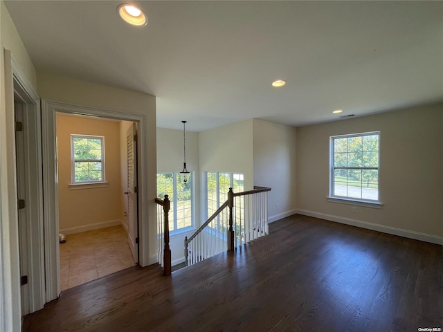 empty room with plenty of natural light and dark hardwood / wood-style floors