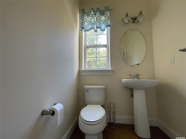 bathroom with toilet, wood-type flooring, and sink