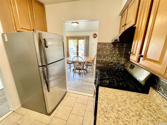 kitchen with light hardwood / wood-style floors, light stone counters, and appliances with stainless steel finishes