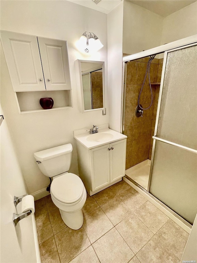 bathroom featuring tile patterned flooring, vanity, toilet, and a shower with door