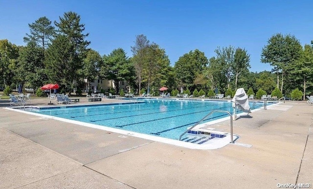 view of swimming pool with a water slide and a patio