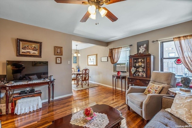 living room featuring hardwood / wood-style floors, ceiling fan with notable chandelier, a healthy amount of sunlight, and cooling unit