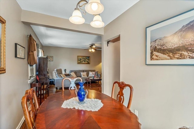 dining area featuring wood-type flooring and ceiling fan with notable chandelier