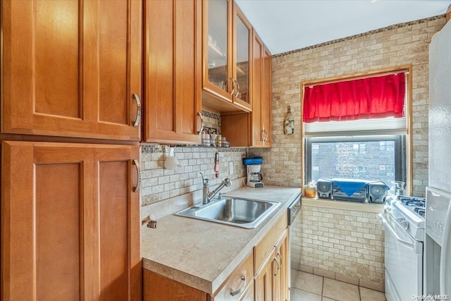 kitchen with dishwasher, sink, light tile patterned floors, and white stove