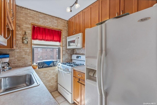 kitchen with sink, light tile patterned flooring, and white appliances