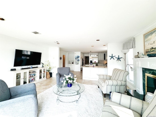 living room featuring a fireplace, light tile patterned floors, and crown molding